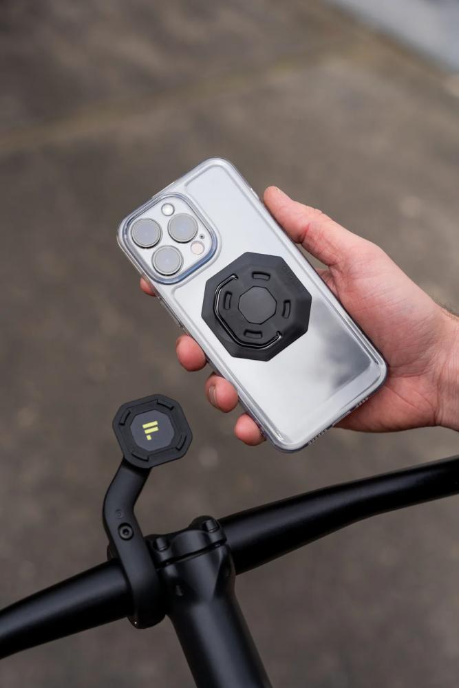 FESCHD Handy-Halterung Bike Bundle schwarz: Eine Hand befestigt ein Handy mit Adapterplatte am Fahrradlenker.