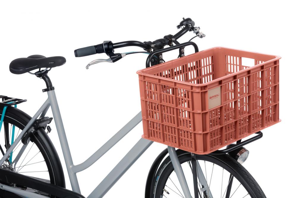 Graues Fahrrad mit stabiler Basil Fahrradkiste Crate L in Terra Rot (40L) vorne am Gepäckträger.