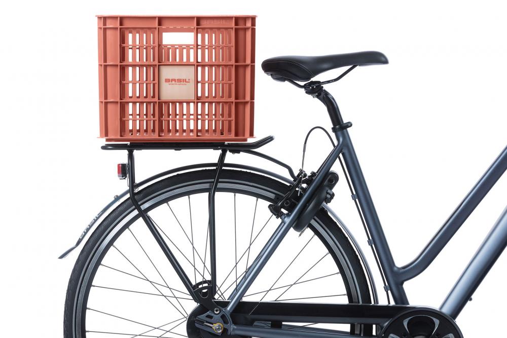 Basil Fahrradkiste Crate L terra red auf Gepäckträger eines Fahrrads, stabile Kunststoffbox 40L mit Tragegriffen.