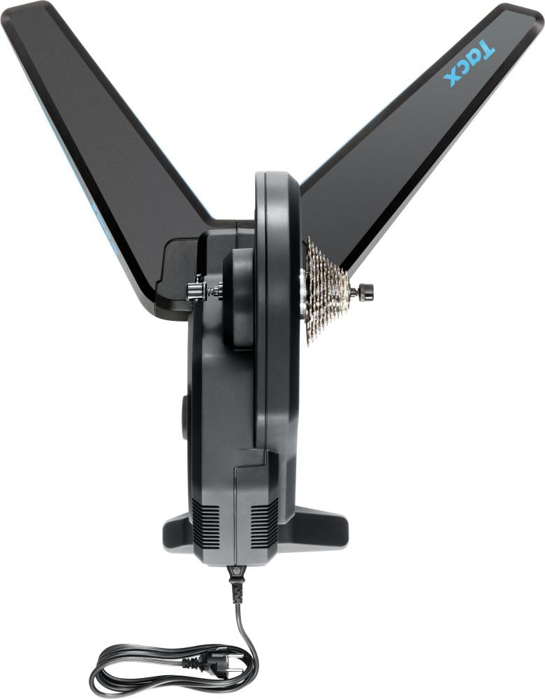 Seitenansicht des Garmin Tacx FLUX 2 Smart-Trainers mit Kassette, ausgeklappten Beinen und Stromkabel.