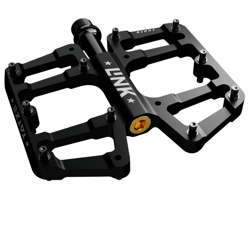 Tatze LINK MTB Titan Plattformpedal, schwarz, mit 10 Pins je Seite und goldenen Akzenten.