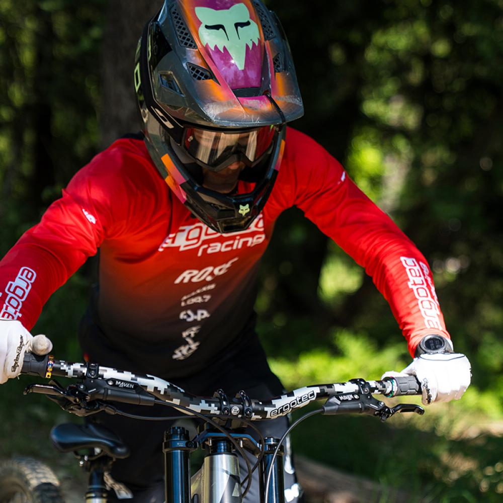 Ergotec Riser Bar 50 Pixel Edition MTB-Lenker 800mm mit Camo-Muster, montiert am Mountainbike, von Fahrer gehalten.