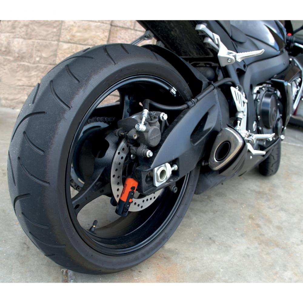 Kryptonite Evolution Compact Disc Lock Bremsscheibenschloss 13mm orange am Motorrad-Hinterrad mit Reminder-Kabel.