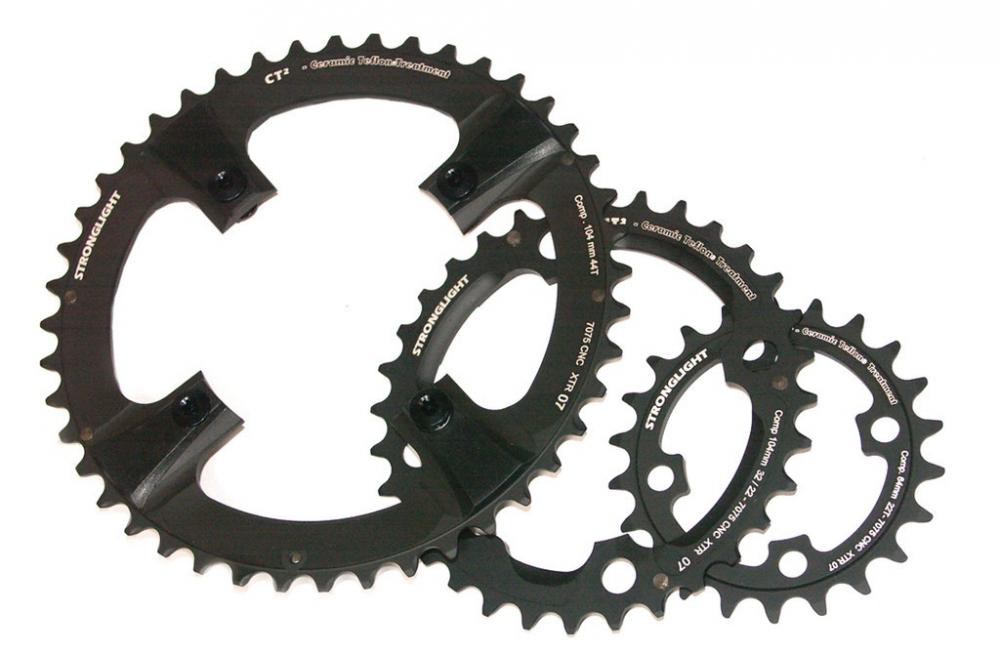 Schwarzes Stronglight MTB-Kettenblatt 64mm LK 22Z 4 Arm, zusammen mit zwei weiteren Stronglight Kettenblättern.