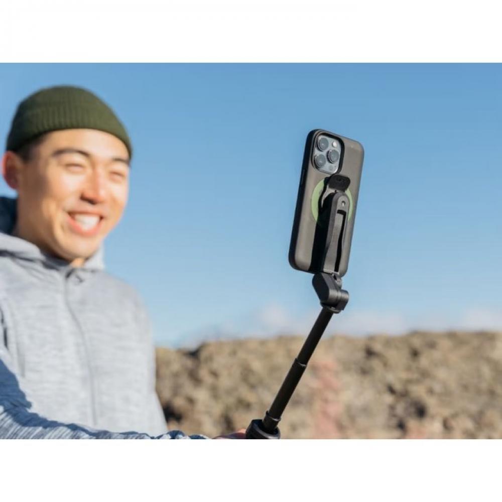 Lachender Mann macht Selfie mit Smartphone auf schwarzem Quad Lock 360 Kopf mit kurzem Hebel an Selfie-Stick im Freien.